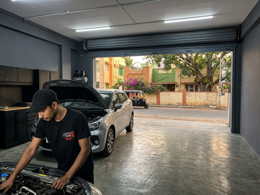 CARZ 2.O workshop bay with a premium sedan under inspection lighting